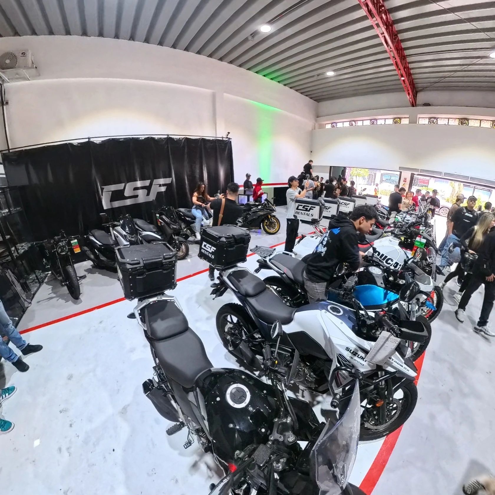 Motocicletas alineadas y visitantes dentro del local de CSF Rentals.